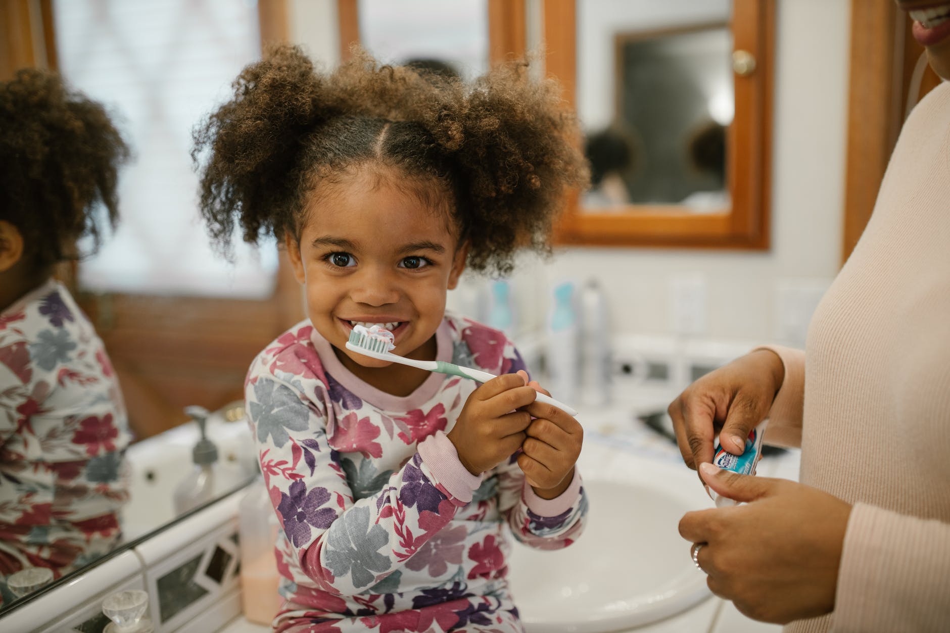 curly haired girl brushing teeth