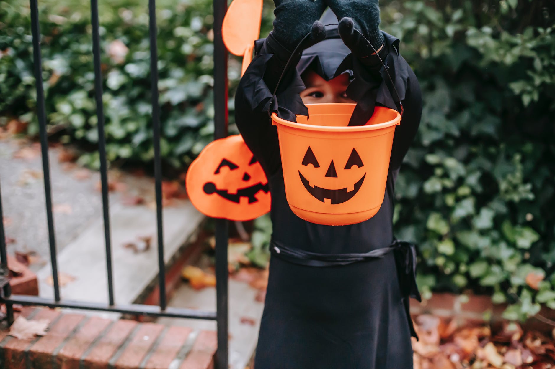 little child in halloween costume having fun in garden