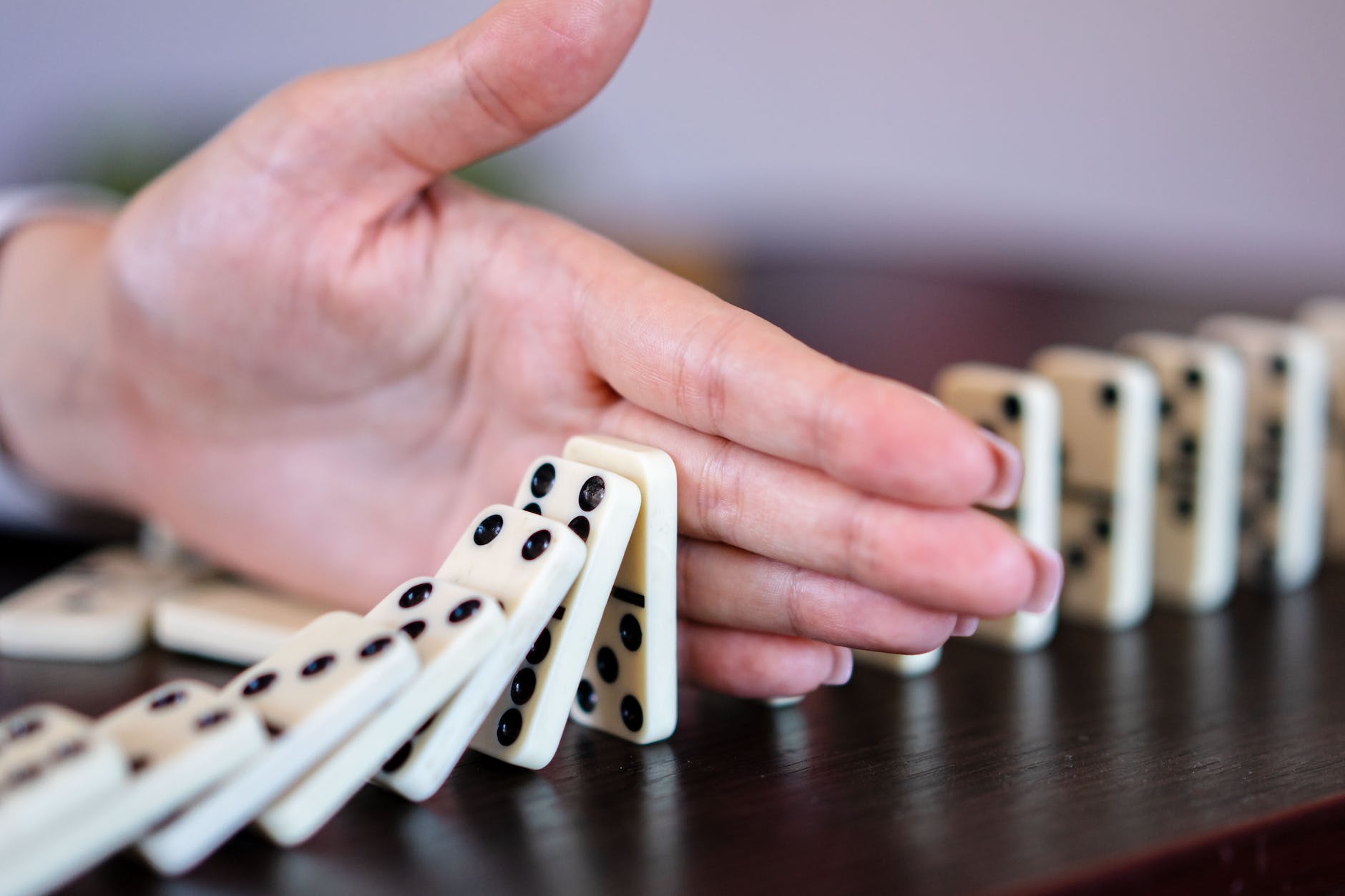 a hand blocking the dominoes