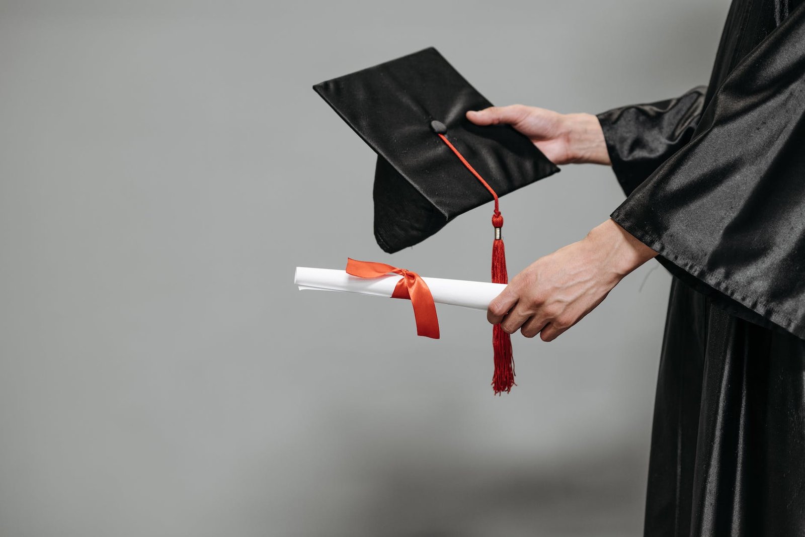 photo of person holding graduation cap and diploma