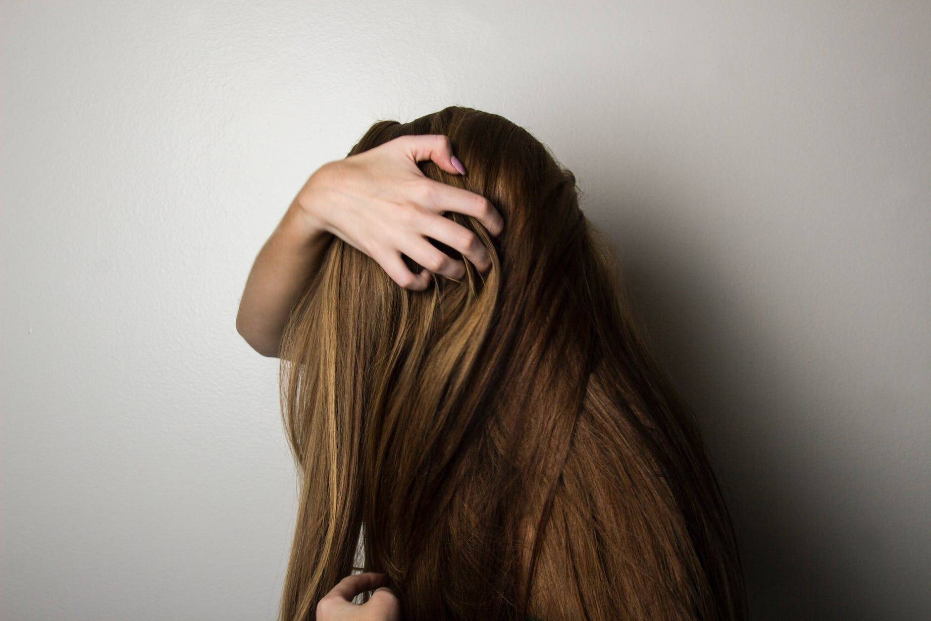 photo of woman covering face with her hair